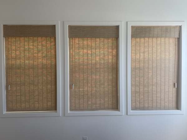 Natural woven shades on three windows